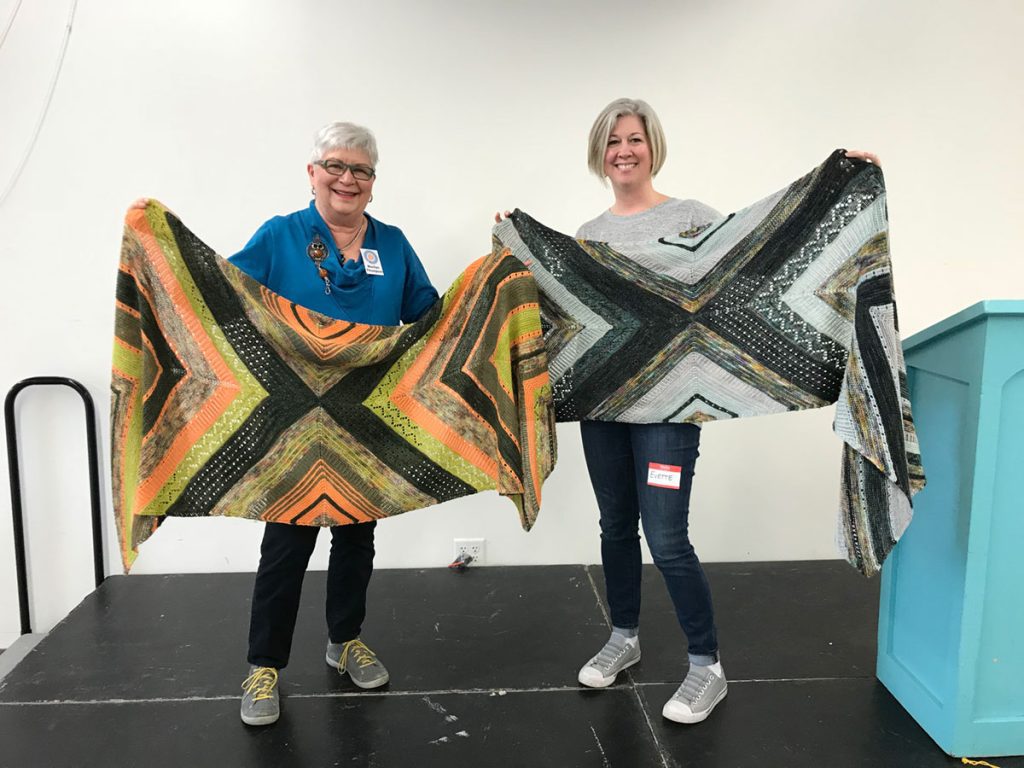 image of two MKG members holding up prize winning shawls
