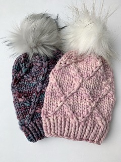 Two hand knit hats with pompoms