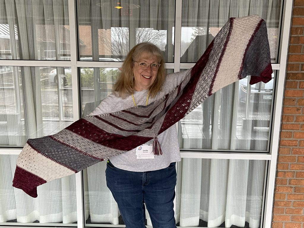 Woman with blond hair and glasses modeling a shawl