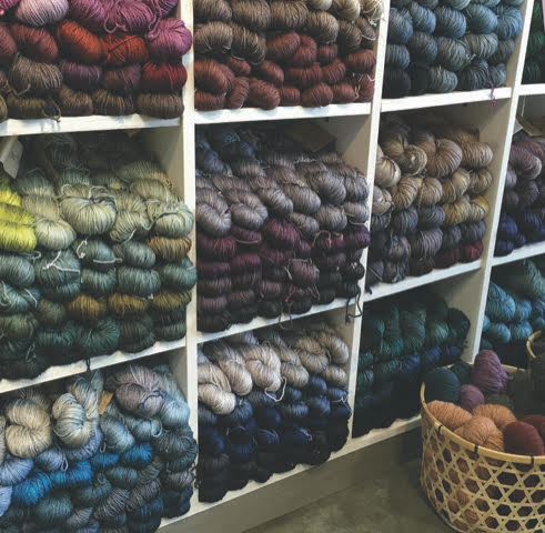 skeins of yarn of different colors on shelves