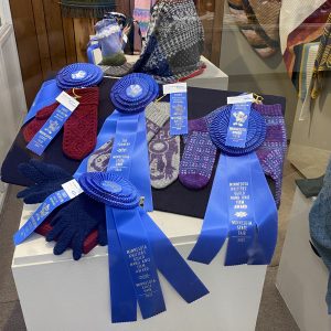 Image of winning mittens and gloves with their ribbons at the Minnesota State Fair.