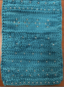 A blue hand knit scarf with beads