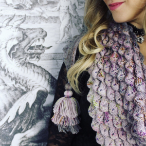 Image of a woman wearing a knit dragon scale shawl