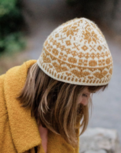 Woman wearing a yellow and white hand knit hat