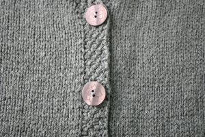 details of a hand knit button band with buttons