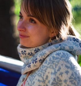 Woman wearing a hand knit sweater and cowl in blues and white