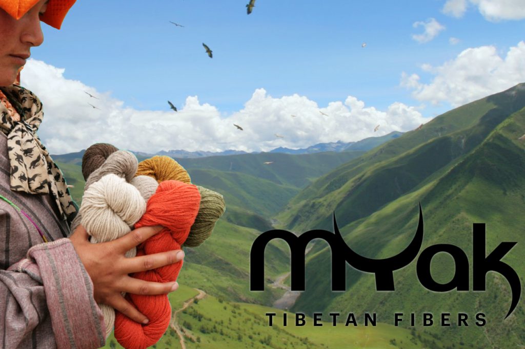 A Tibetan woman holding yarn with a green mountains in the background and the Myak logo.