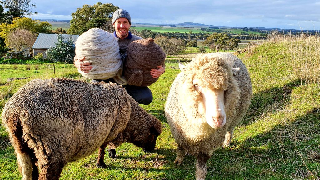 Picture of an Australian farmer with sheep and roving.