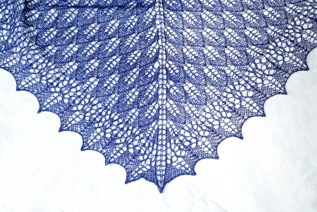 A blue lace shawl on a white background