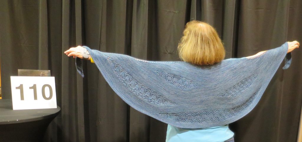 Woman modeling hand knit blue shawl