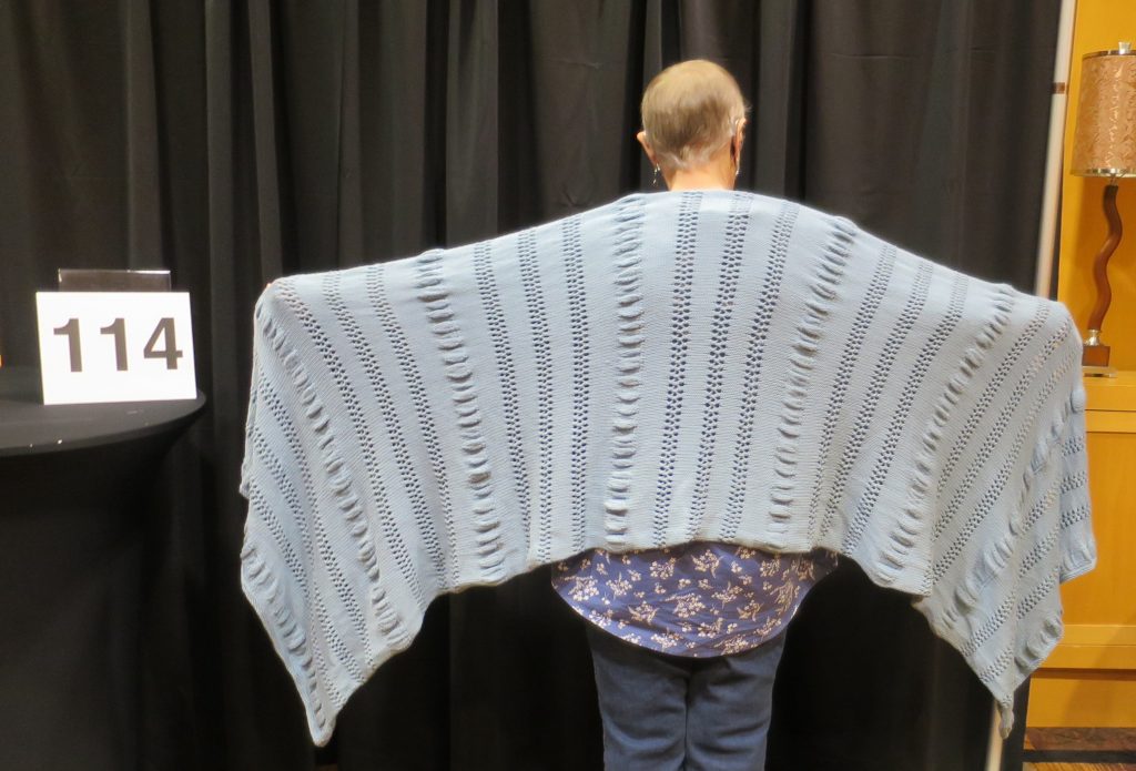 Woman modeling grey hand knit shawl