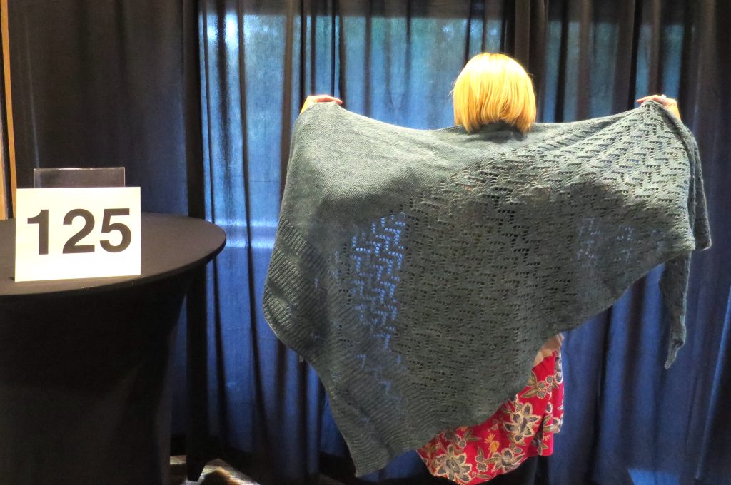 woman models light blue hand knit shawl