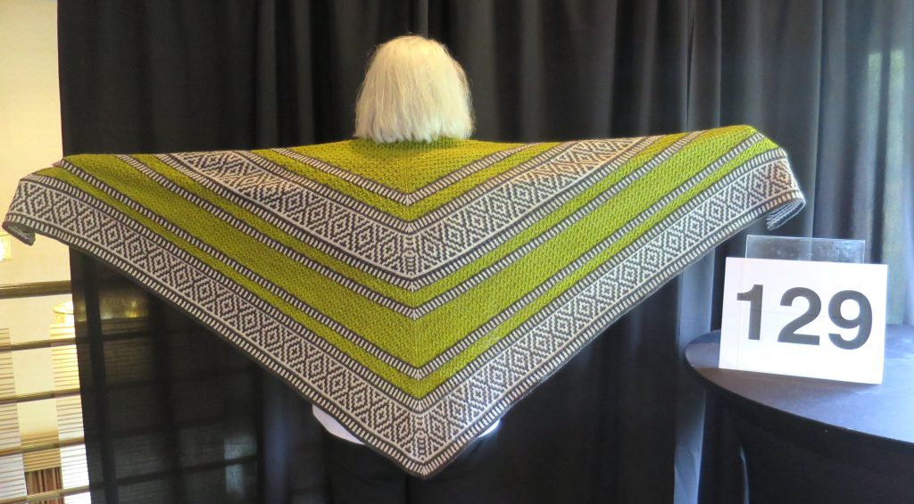 Woman models a hand knit shawl