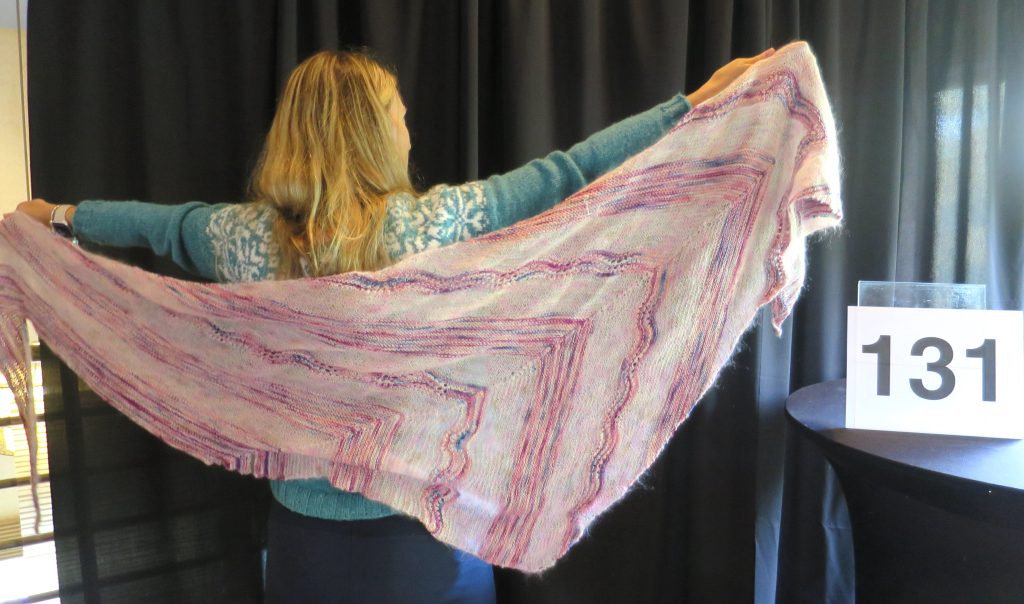 A woman models a pink & white shawl