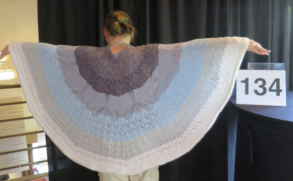 A woman models a hand knit lace shawl