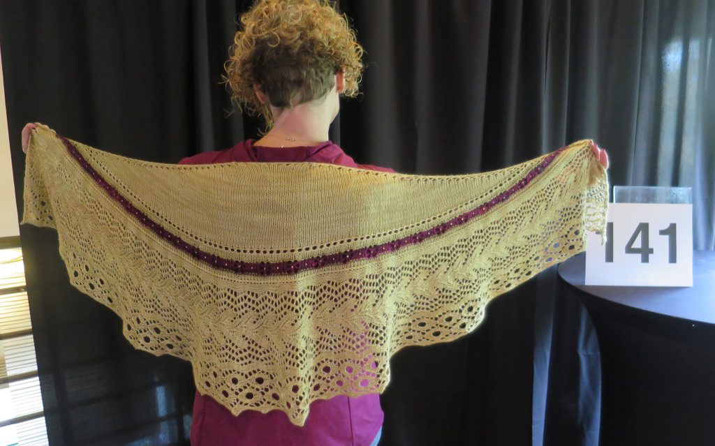 A woman models a hand knit shawl