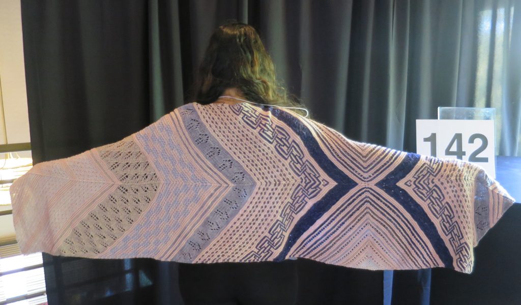 A woman models a hand knit lace shawl