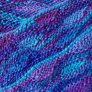 photo of knitting in blue and purple yarn using short rows for shaping.