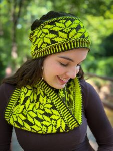 A woman wears hand knit colorwork hat and scarf in black and yellow